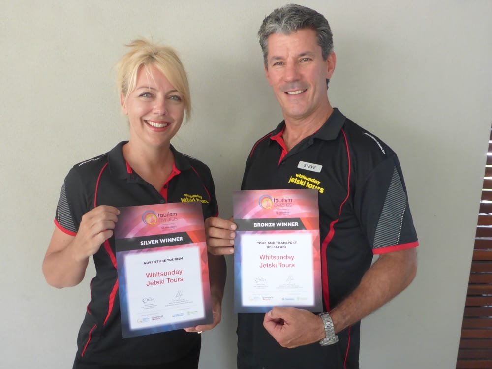 Steve and Toni Ward showing certificates for Whitsunday Jetski Tours winning silver for Adventure Tourism and bronze for Tour and Transport Operators at the Queensland Tourism Awards.