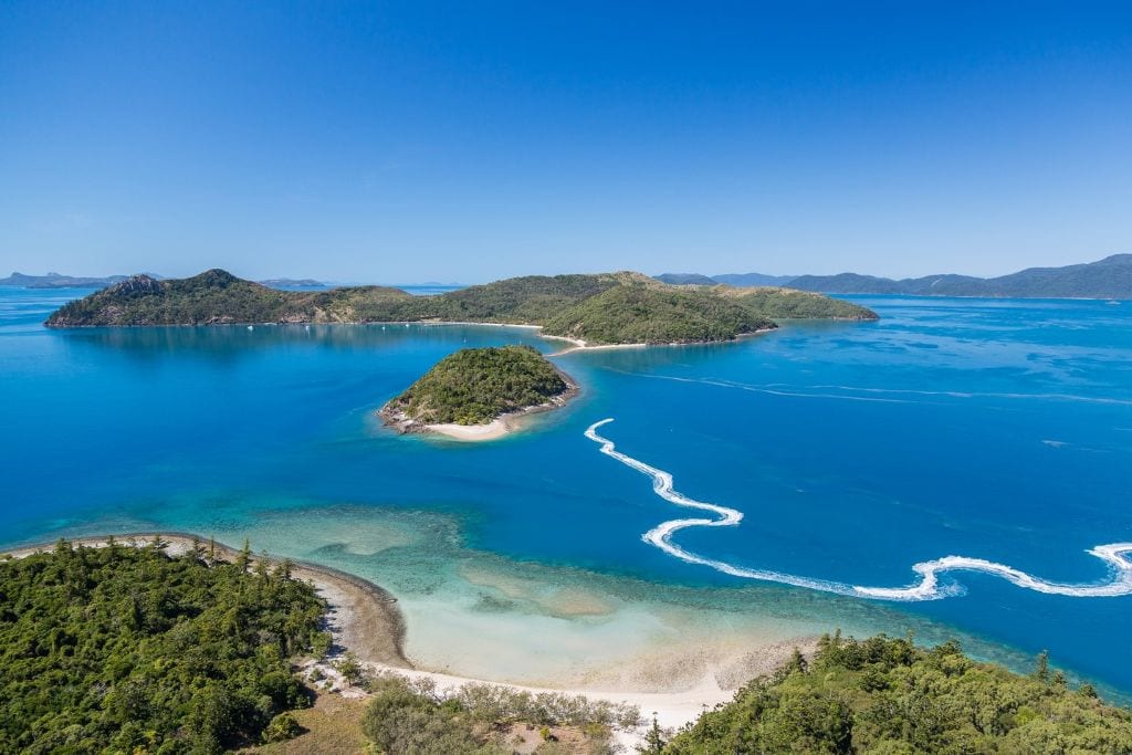 A group on a jet ski tour in the beautiful turquoise waters of the Whitsundays as seen from above.