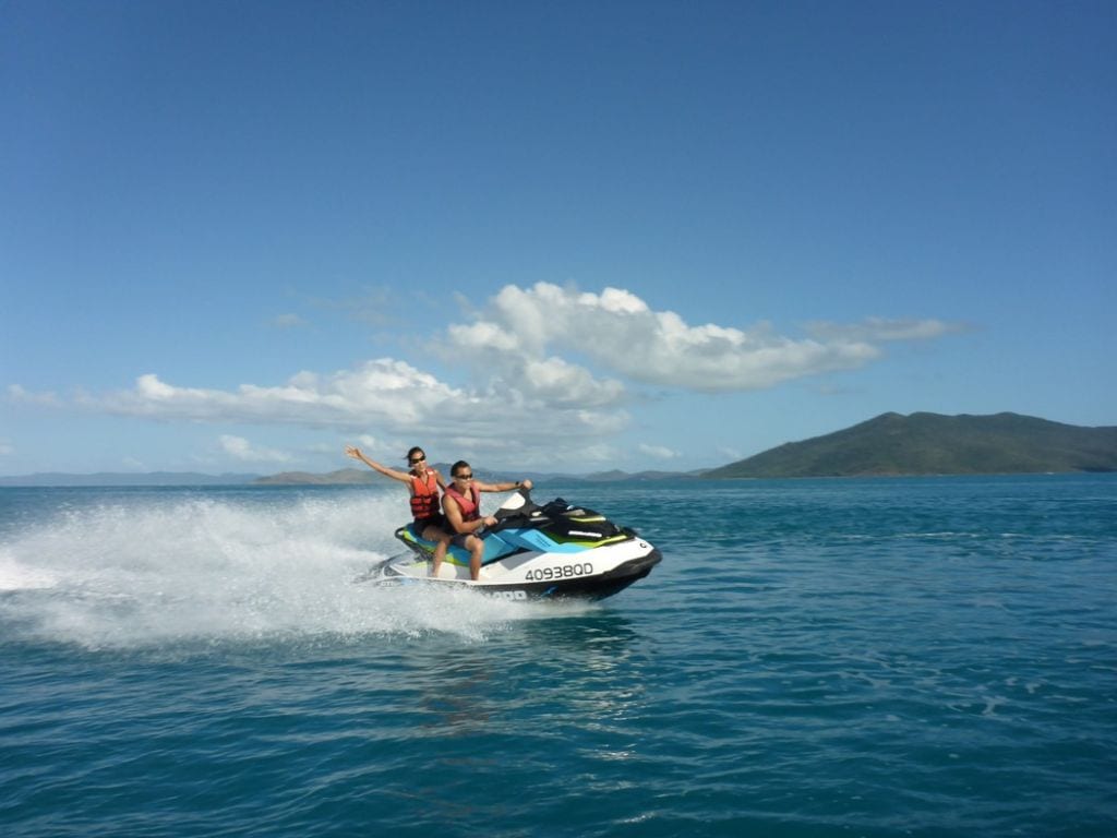 Two people driving their hired jet ski in the beautiful ocean surrounding the Whitsundays.