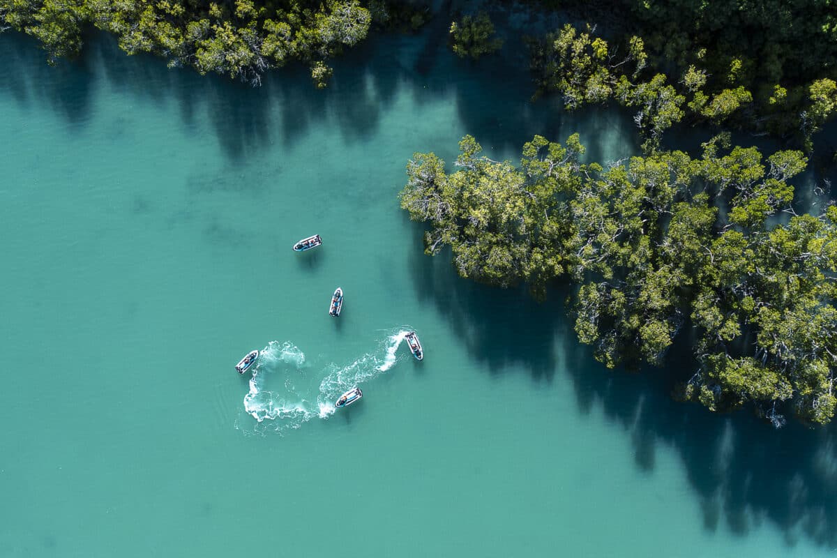 A group of jet skis seen from above while jet skiing in crystal clear waters around the islands of the Whitsundays.